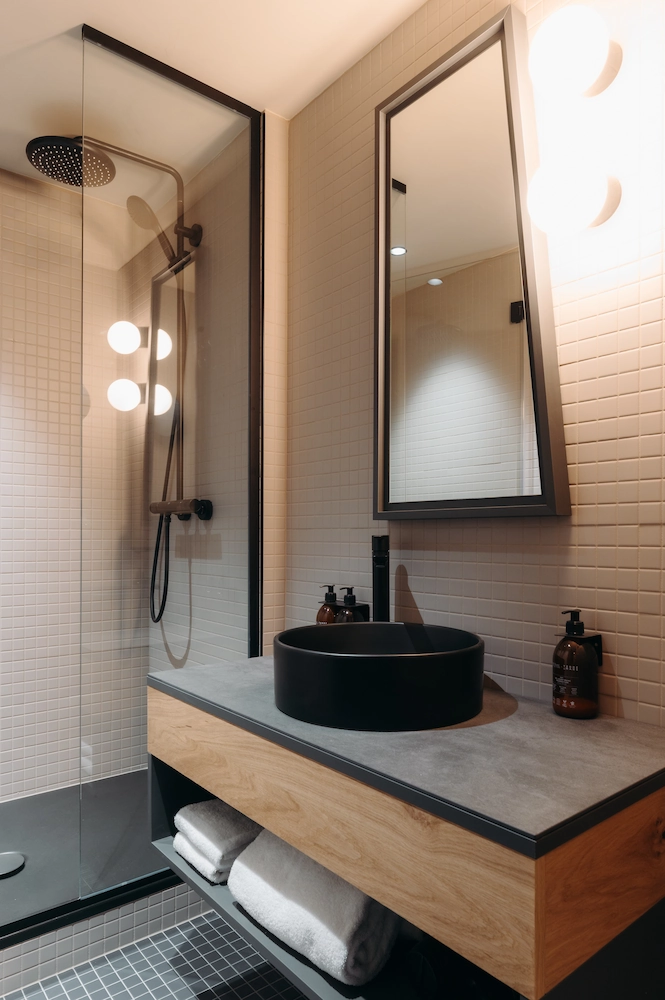 Salle de bain avec douche à l'italienne, vasque ronde noire sur meuble en bois et miroir, Chambre Cosy