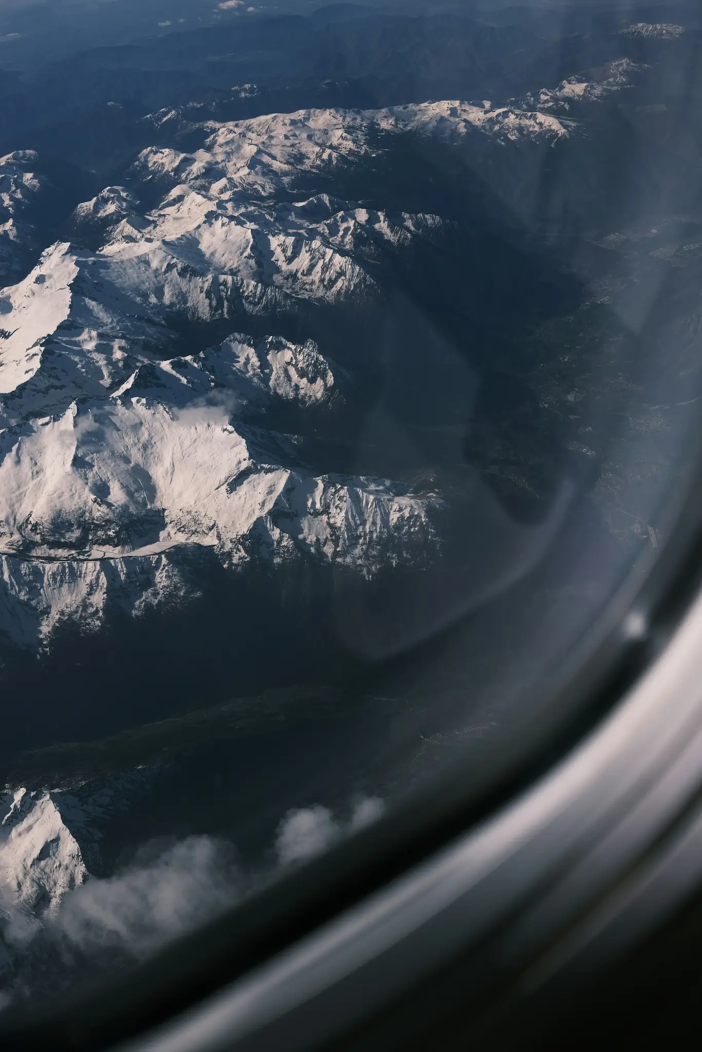 View from an airplane window of a snow-capped mountain range