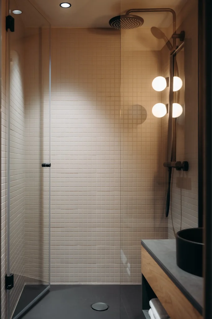 Douche à l'italienne avec paroi vitrée, pomme de douche de pluie et éclairage design